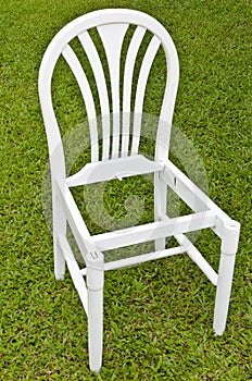 Uncomplete White Chair on Green Grass photo