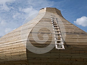 Uncompleted wooden onion-shaped dome with a ladder on the sky background