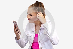 Uncomprehending woman looks at the smartphone