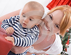 Unconditional love - mother and baby opening a Christmas or birthday present