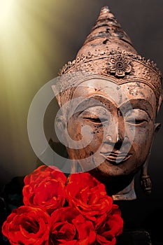 Unconditional love. Spiritual enlightenment. Traditional Buddha and red roses