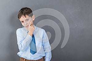 Unconfident boy student before dark background with copy-space