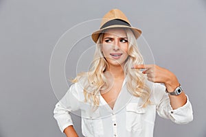 Unconfident embarrassed young woman pointing finger away