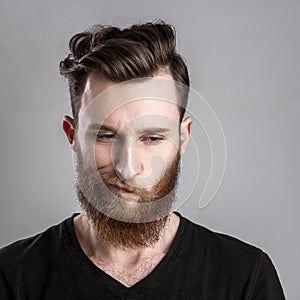 Unconfident and worried young man isolated on gray background