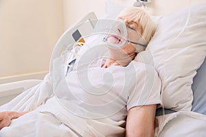 Unconscious elderly woman wearing an oxygen mask