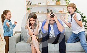 Uncontrollable Children Shouting Loudly Misbehaving Standing Near Desperate Parents Indoor