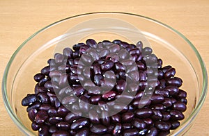 Uncoocked red beans in a cristal bowl on wooden