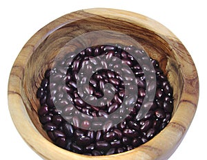 Uncoocked red beans in a olive wood bowl. Gernika