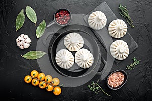 Uncooked Baozi chinese dumplings. Azian dumplings, on black stone background, top view flat lay