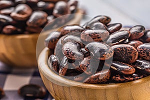 Uncooked beans in wooden bowles on kitchen table