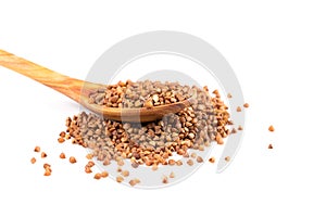 Uncooked buckwheat on wooden spoon