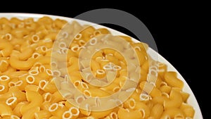 Uncooked chifferi rigati pasta rotating