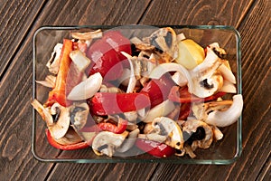 Uncooked dish with raw ingridients: onion, pepper, potato, mushrooms