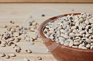 Uncooked Dried Black Eyed Peas in Bowl on Wooden Table