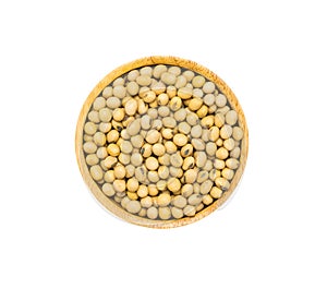 Uncooked dry Soybeans in wooden bowl on white background, top view