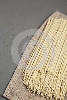 Uncooked dry white Ramen noodles over gray surface, low angle view. Copy space