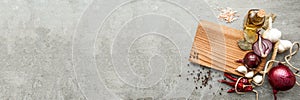 Uncooked fresh diced beef meat with herbs and oil on an old rustic wooden kitchen board over stone background. Top view