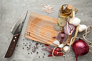 Uncooked fresh diced beef meat with herbs and oil on an old rustic wooden kitchen board over stone background. Top view