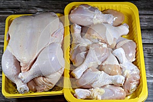 uncooked fresh raw chicken legs drumsticks and thighs hindquarter leg quarters with skin and bones and Fresh raw chicken with skin