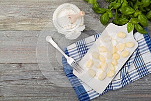 Uncooked homemade potato gnocchi with tomatoes or mushrooms with flour