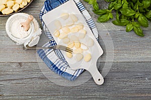 Uncooked homemade potato gnocchi with tomatoes or mushrooms with flour