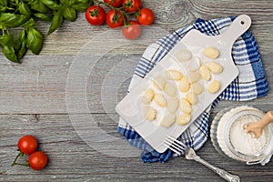 Uncooked homemade potato gnocchi with tomatoes or mushrooms with flour