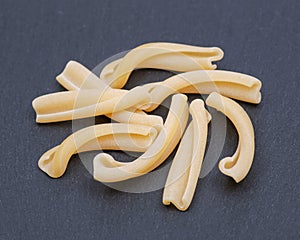 Uncooked Italian Casarecce pasta made from organic durum wheat semolina on natural stone. Macaroni product.