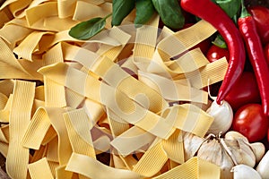 Uncooked Italian noodles with garlic, basil, tomatoes cherry and