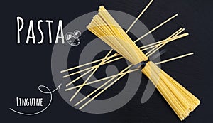 Uncooked Italian pasta Linguine on black slate stone background