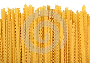 Uncooked Italian pasta mafaldine on a white