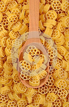 Uncooked italian pasta rotelle in a spoon