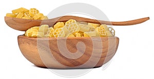 Uncooked italian pasta rotelle in a wooden bowl on a white