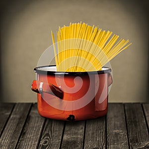 Uncooked Italian spaghetti in a red pot