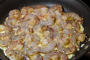 Uncooked jumbo shrimp sauteed in melted butter and garlic