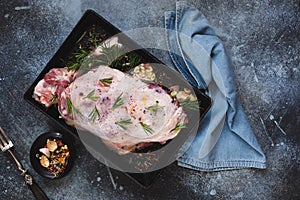 Uncooked leg of spring lamb in roasting tin