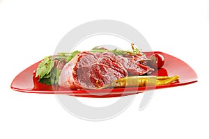 Uncooked meat medallion on red