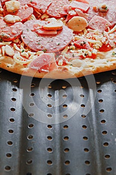 Uncooked meat pizza on a black tray