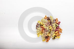 uncooked multi colored pasta isolated on white background.