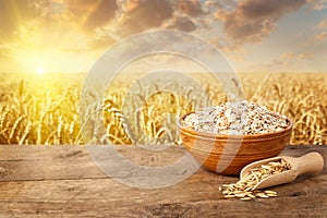 Uncooked oat flakes in bowl on table