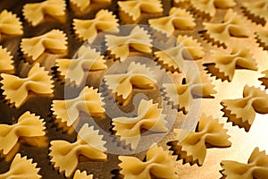 Uncooked organic farfalline pasta on table, closeup