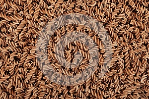 Uncooked Pasta di Lino, close-up. Flaxseed gluten free pasta is rich in fiber, iron, B vitamins and Omega-3. Fusilli made from