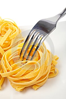 Uncooked pasta nests and fork