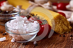 Uncooked pasta, tomatoes on wooden background, top view, close-up, selective focus