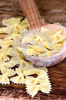 Uncooked pasta in wooden spoon
