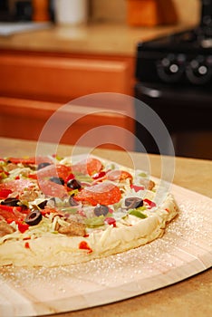 Uncooked pizza on a wooden peel