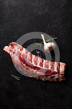 Uncooked pork ribs on dark textured background