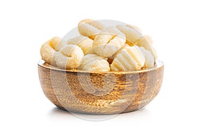 Uncooked potato gnocchi in bowl isolated on white background