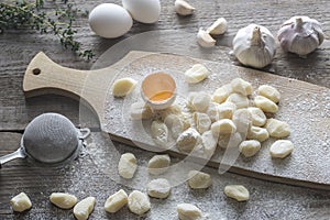 Uncooked potato gnocchi with ingredients