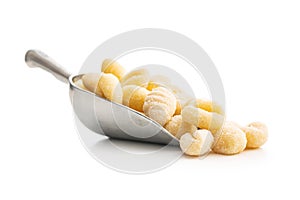 Uncooked potato gnocchi in scoop isolated on white background