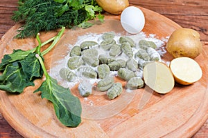 Uncooked potato gnocchi with spinach among the several ingredients photo